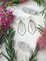 Courts hammered polygon earrings on white background showing light reflecting through quartz