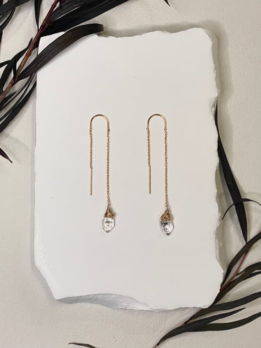 threader earrings featuring a tiny delicate gold chain and a wire wrapped Herkimer diamond on the end￼