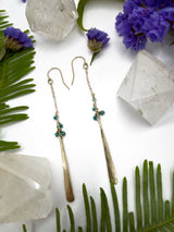 earrings consisting of a short length of chain with small turquoise beads gradually hanging off with a metal hammered paddle dangling at the end
