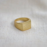 Signet ring showing light reflecting on linen background