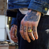 Man wearing gold toned signet ring on ring finger