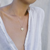 Woman wearing Roma necklace hangs just below clavicle
