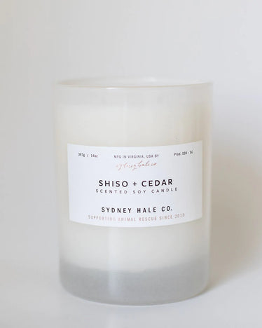 Cream color candle in frosted white glass jar with white label